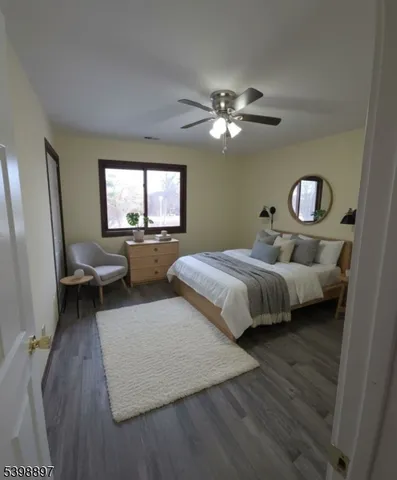 a bedroom with a large bed chandelier and a window