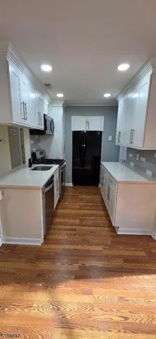 a large kitchen with stainless steel appliances granite countertop a stove and a sink