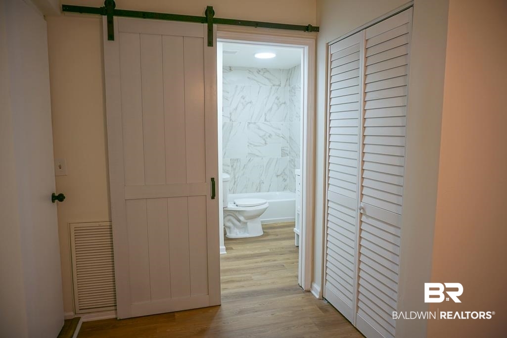 4734 Kirkwell Drive Mobile, AL 36619 - Photo 10 of 18 Corridor with a barn door and light hardwood / wood-style flooring