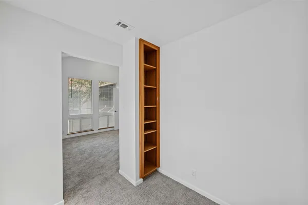 an empty room with windows and closet