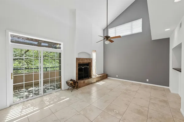 a view of an empty room with a fireplace and a window