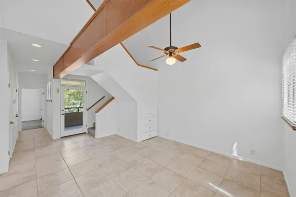 an empty room with white walls and ceiling fan
