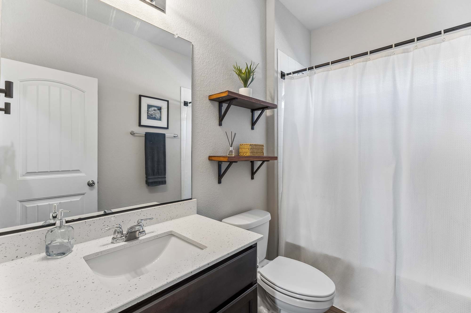 124 Moravia Road Georgetown, TX 78626 - Photo 28 of 38 Gleaming stone countertops and a modern vanity highlight this updated bathroom layout.