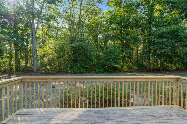 a wooden deck with trees in front of it