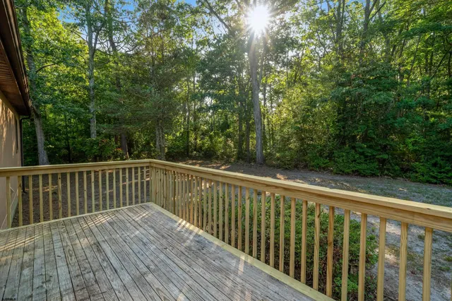 a balcony with wooden floor and trees in the back