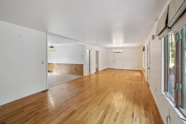 a view of empty room with wooden floor and window
