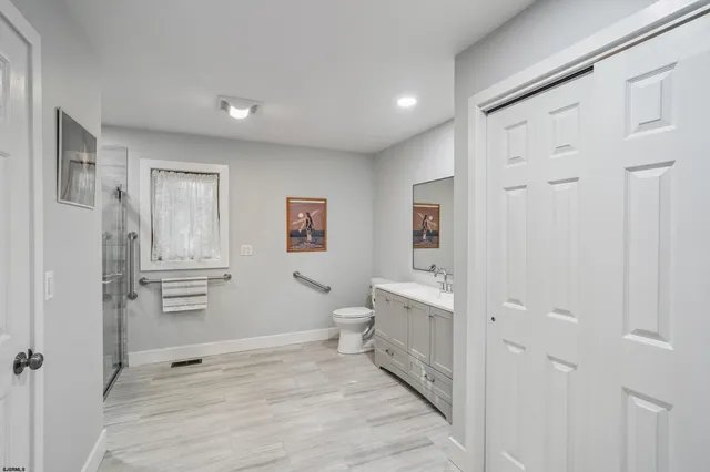 a bathroom with a sink a toilet and shower