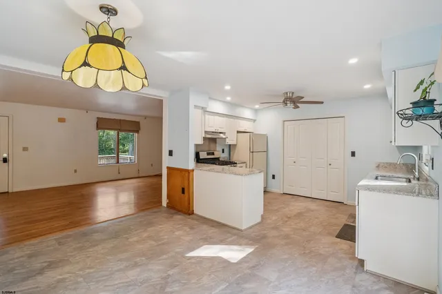 a kitchen with granite countertop a sink a counter top space appliances and cabinets
