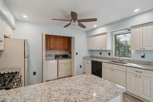 a kitchen with stainless steel appliances granite countertop a sink stove and cabinets
