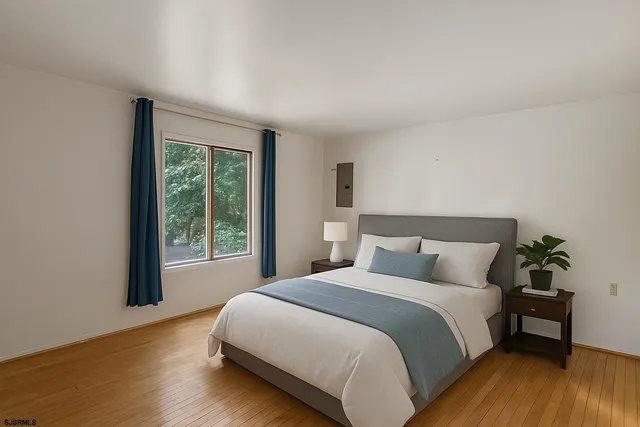 a bedroom with a bed lamp and a large window