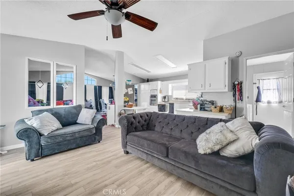 a living room with furniture and a view of kitchen