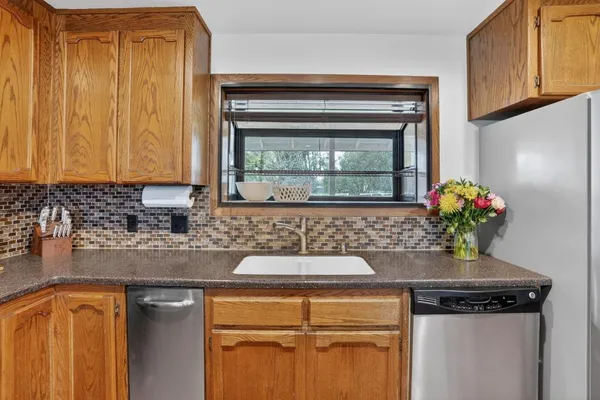 a kitchen with granite countertop cabinets a stove and a refrigerator