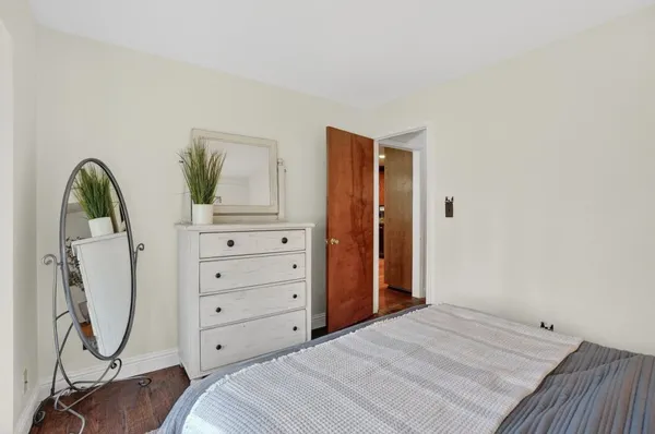 a bedroom with a bed and a mirror on dresser