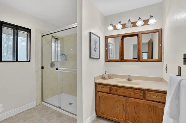 a bathroom with a sink mirror and a shower