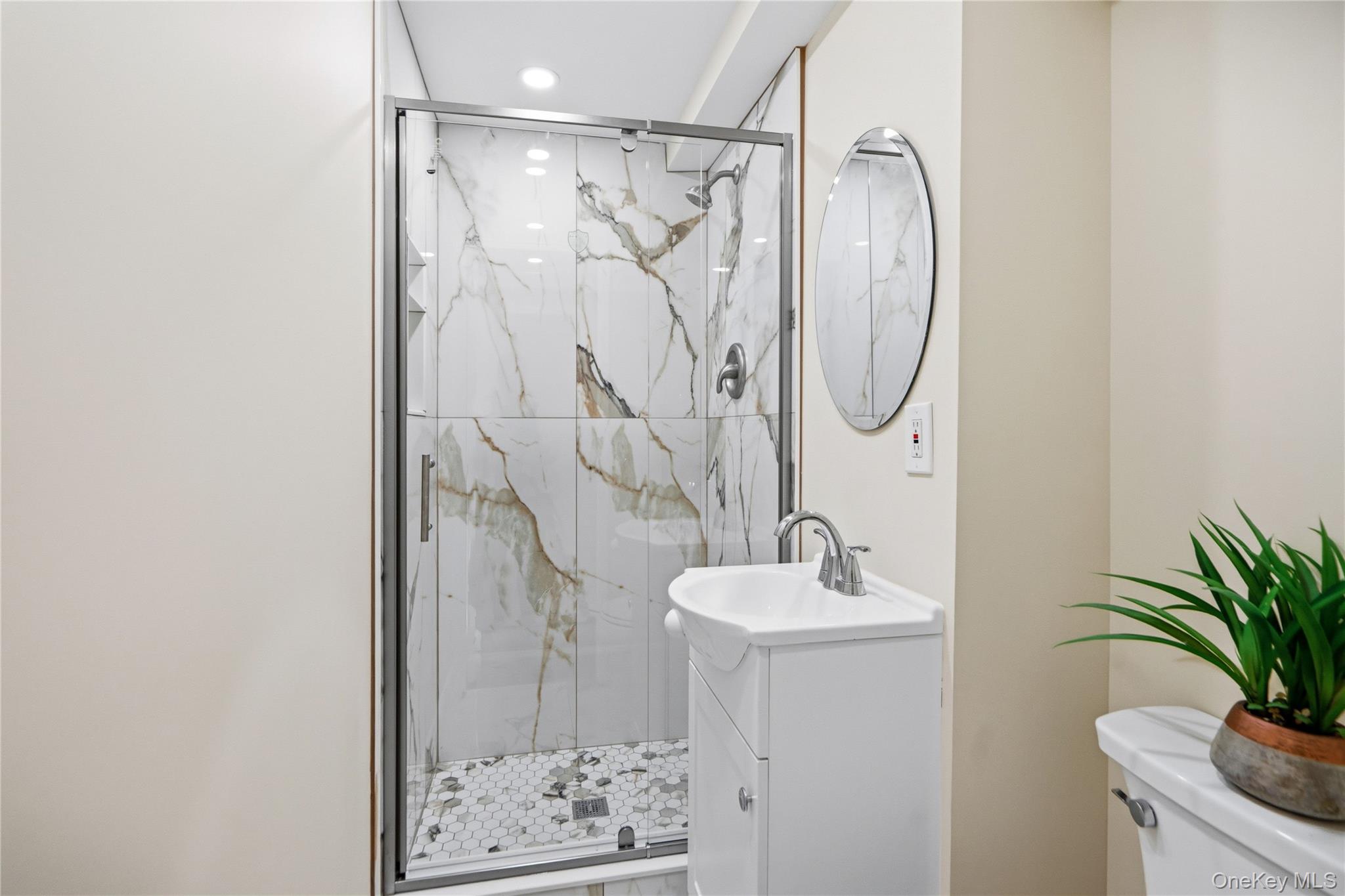 183 North Marginal Road Jericho, NY 11753 - Photo 24 of 28 First Floor Shower enclosure with glass door, large format tile surround, and hexagonal tile floor