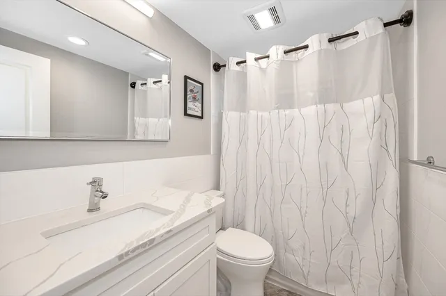 a bathroom with a sink toilet and shower