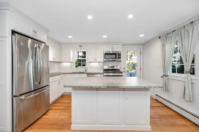 a kitchen with stainless steel appliances granite countertop a refrigerator a sink a stove and a microwave