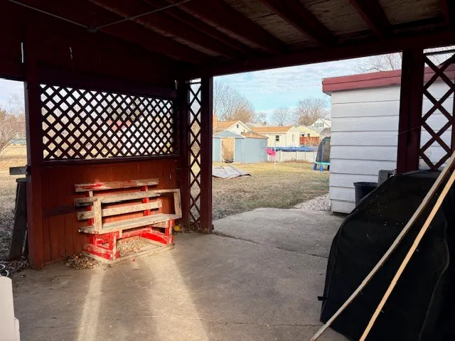 a backyard of a house with wooden fence and a bench