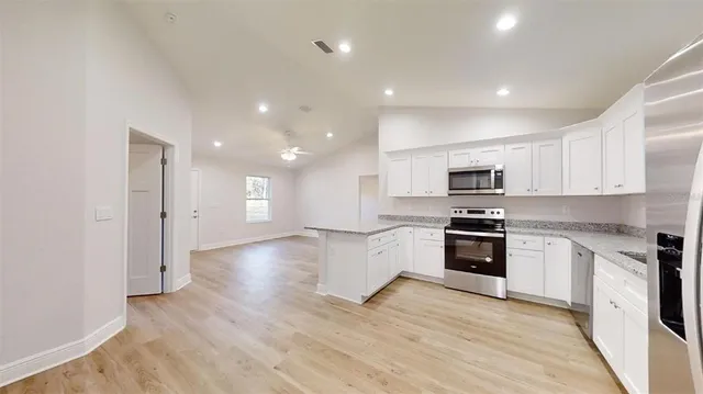 a view of a hallway with wooden floor and a cabinet