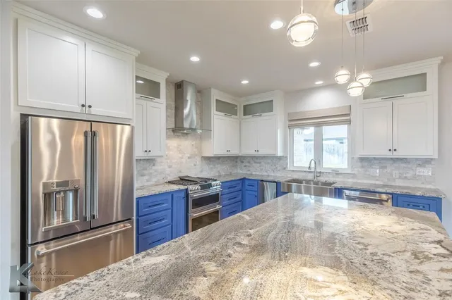 a kitchen with kitchen island granite countertop wooden cabinets and stainless steel appliances