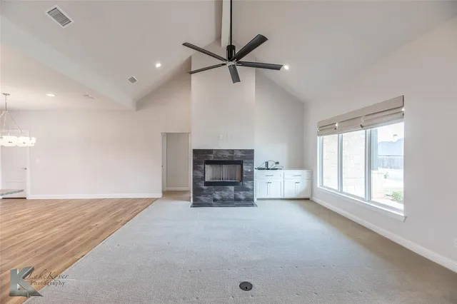 an empty room with windows and fireplace