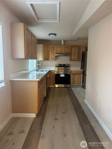 a kitchen with stainless steel appliances granite countertop a sink a stove and a refrigerator