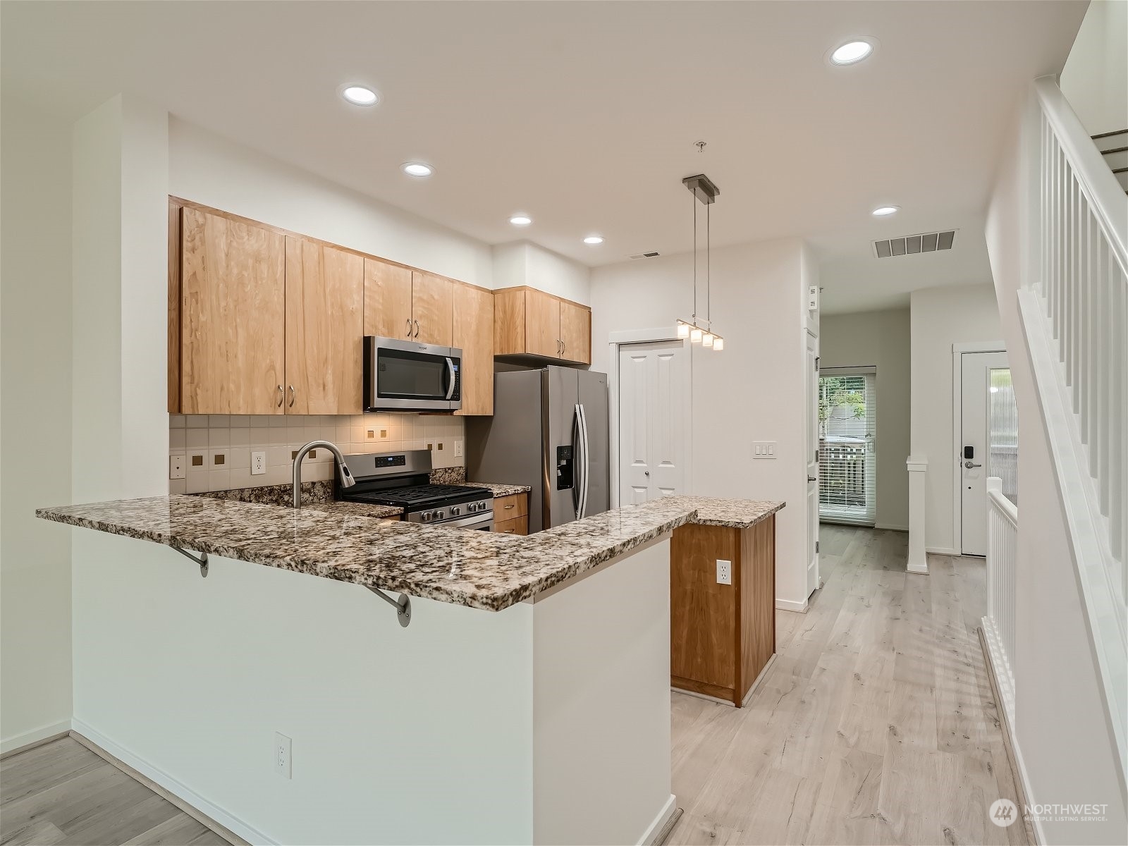 101 Sky Ridge Road Northwest, Unit 502 Issaquah, WA 98027 - Photo 18 of 31 a kitchen with stainless steel appliances granite countertop a refrigerator and a stove top oven