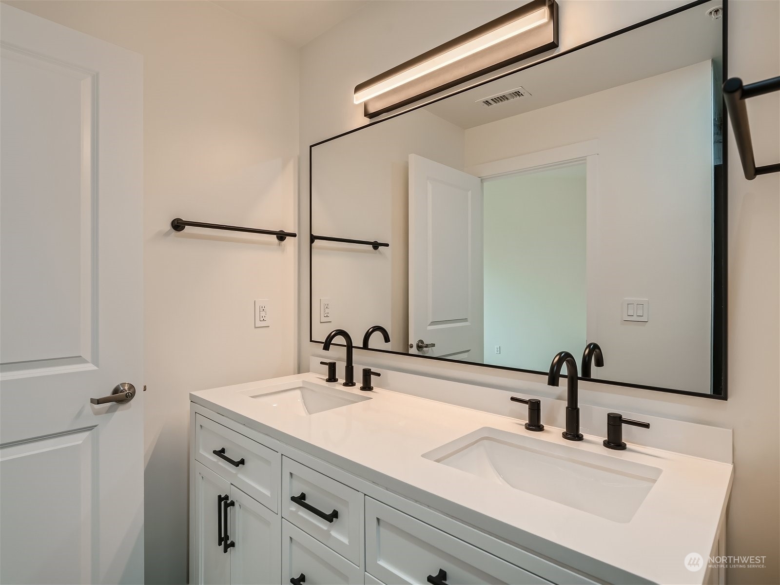 101 Sky Ridge Road Northwest, Unit 502 Issaquah, WA 98027 - Photo 25 of 31 a bathroom with a double vanity sink and a mirror