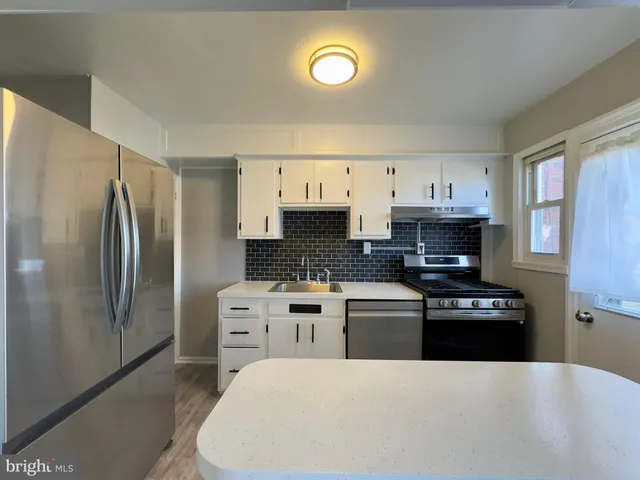 a kitchen with stainless steel appliances a stove refrigerator sink and cabinets