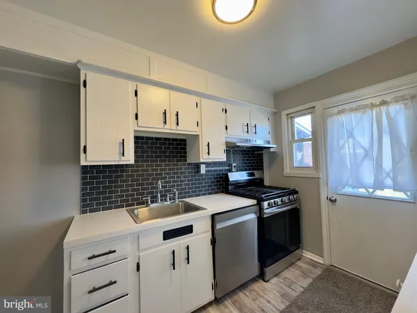 a kitchen with granite countertop a stove sink and cabinets