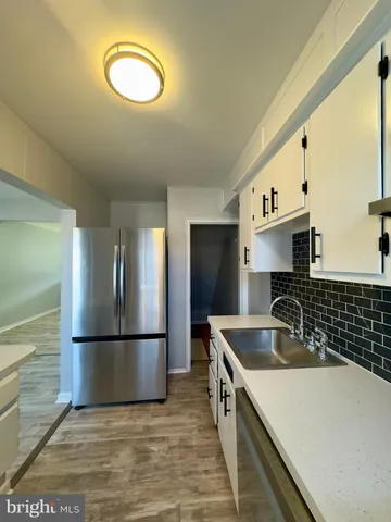 a kitchen with stainless steel appliances granite countertop a sink and a refrigerator