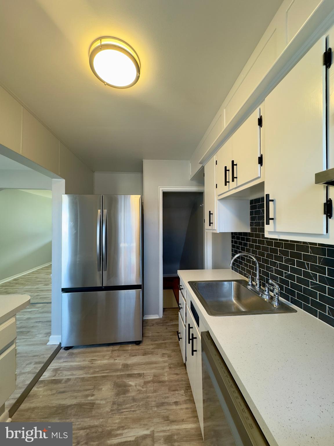 7716 Wynbrook Road Baltimore, MD 21224 - Photo 6 of 15 a kitchen with stainless steel appliances granite countertop a sink and a refrigerator