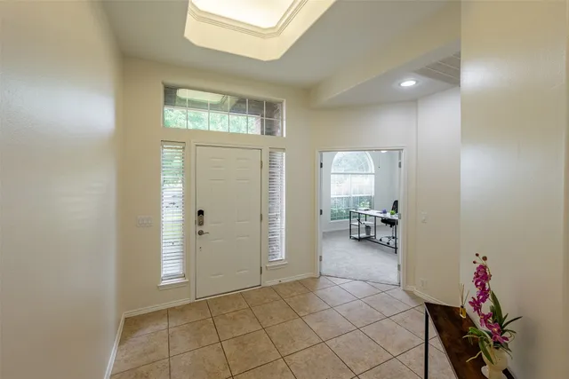 a living room with furniture a chandelier and a flat screen tv