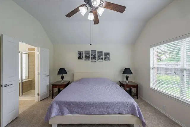 a bedroom with a bed chandelier and a window