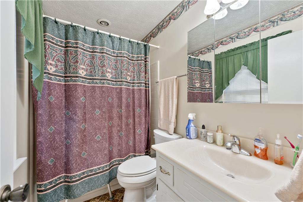 6633 Cameron Road Morrow, GA 30260 - Photo 18 of 41 a bathroom with a sink a toilet a mirror and shower