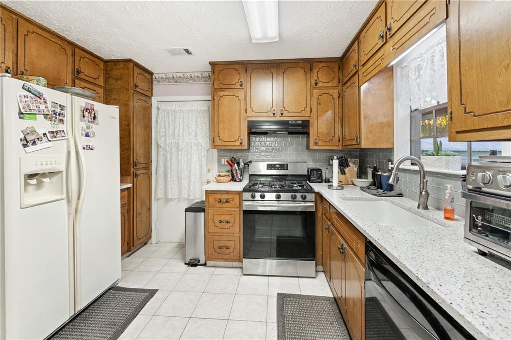 6633 Cameron Road Morrow, GA 30260 - Photo 10 of 41 a kitchen with stainless steel appliances granite countertop a refrigerator a stove a sink and dishwasher