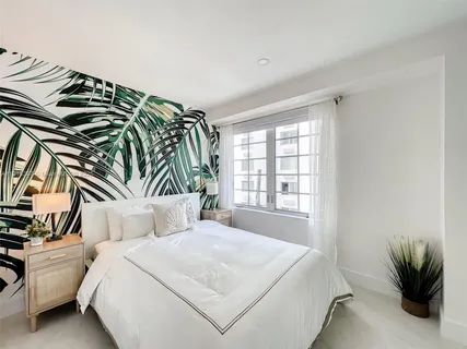 a bedroom with a bed and a potted plant