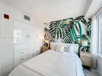 a bedroom with a bed and a potted plant