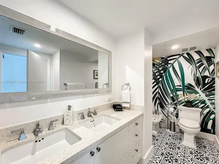 a bathroom with a sink a toilet and a mirror