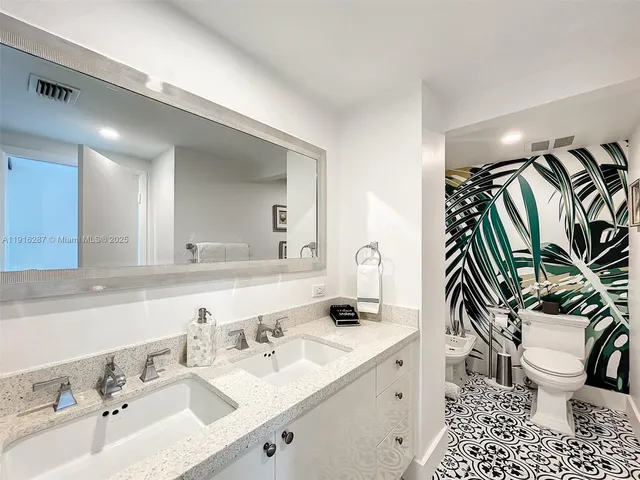 a bathroom with a sink a toilet and a mirror