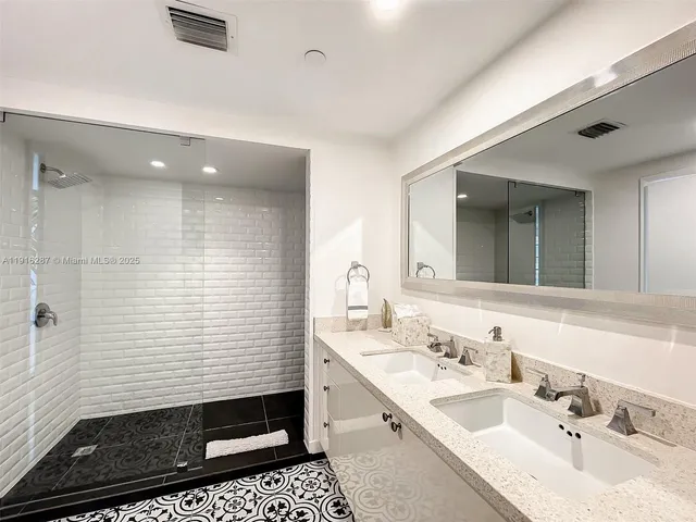 a bathroom with a sink shower and a mirror