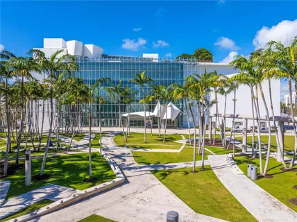 a view of a swimming pool with a lawn chairs and palm trees