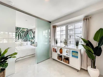 a white bed sitting in a room next to a window