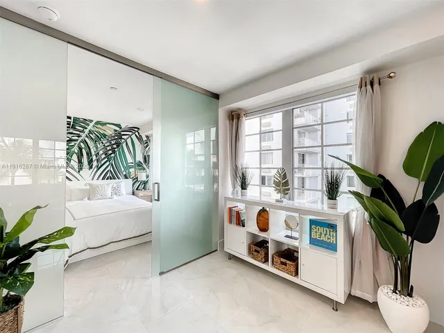 a white bed sitting in a room next to a window