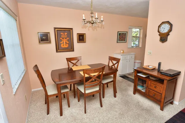 a view of a dining room with furniture and a chandelier
