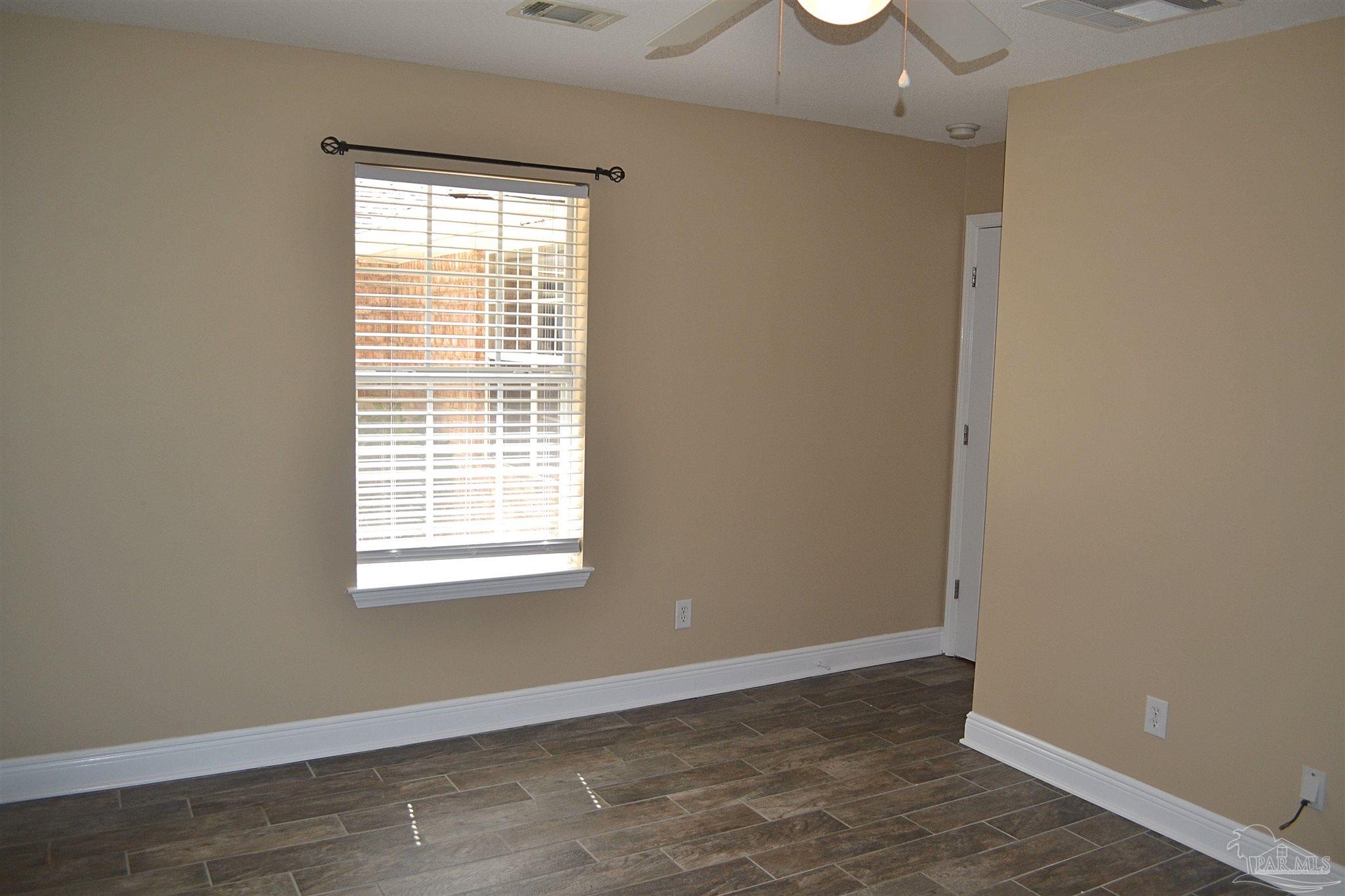 3055 Wallace Lake Road Pace, FL 32571 - Photo 18 of 33 a view of an empty room with wooden floor and a window