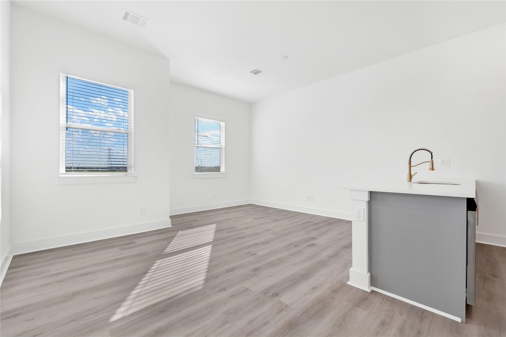 3210 Frying Pan Place, Unit A Katy, TX 77449 - Photo 12 of 39 an empty room with wooden floor and windows