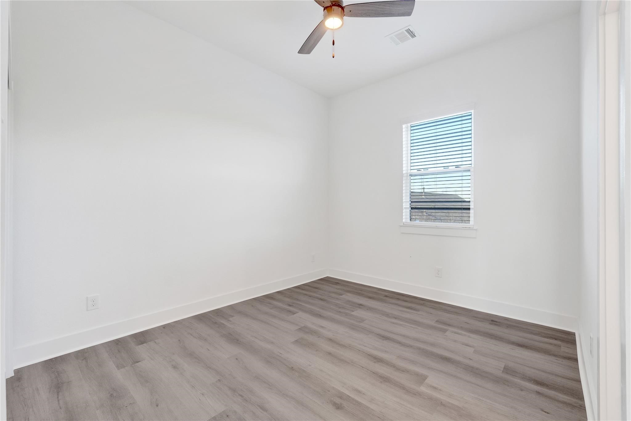 3210 Frying Pan Place, Unit A Katy, TX 77449 - Photo 27 of 39 an empty room with wooden floor and windows