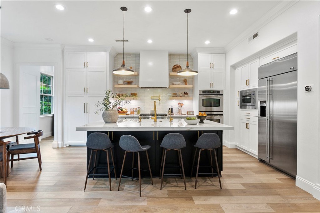 3 Adele Street Ladera Ranch, CA 92694 - Photo 13 of 34 a kitchen with stainless steel appliances granite countertop a table chairs sink and cabinets