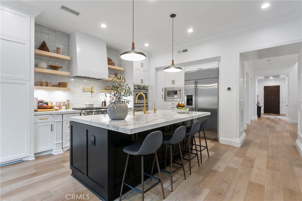 3 Adele Street Ladera Ranch, CA 92694 - Photo 14 of 34 a kitchen with stainless steel appliances kitchen island a large island in the center and cabinets
